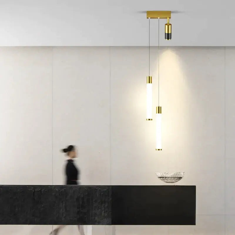 Modern minimalist decorbites golden pendant chandelier with three cylindrical gold-toned bulbs and black accents for living room decor