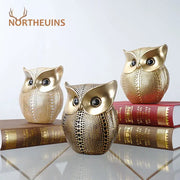 Three golden perforated owl figurines with black eyes metallic finish modern decorbites animal statues for living room