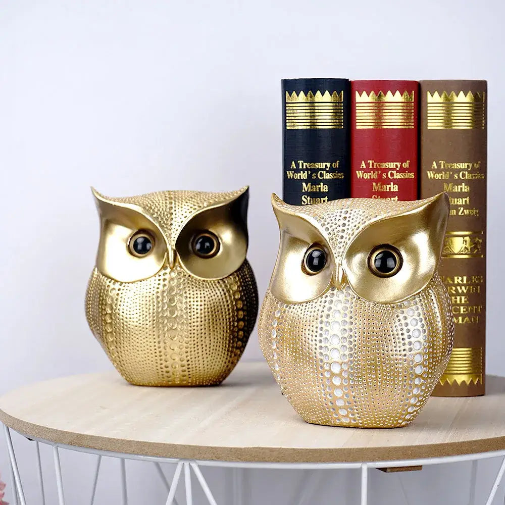 Two modern golden owl figurines with textured perforations and glossy black eyes as decorbites animal statues