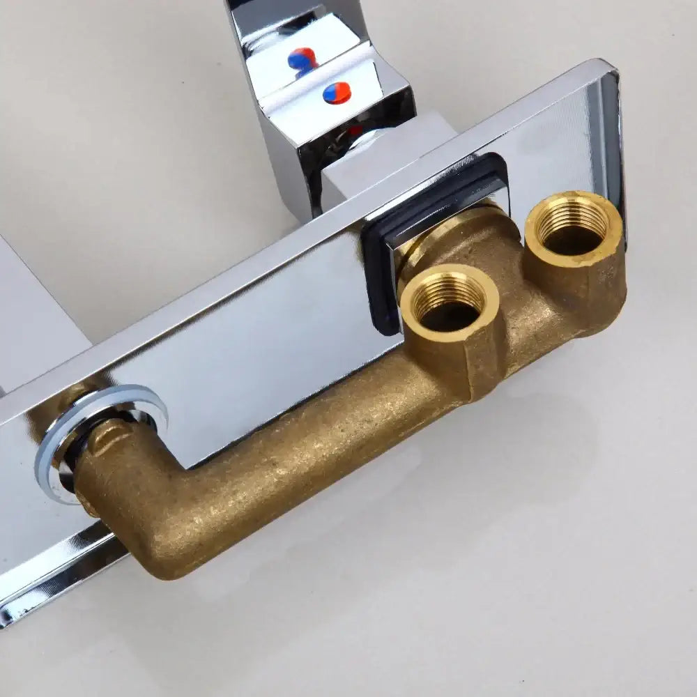 Modern golden polished wall mount faucet with chrome finish brass piping and red and blue temperature indicator knobs