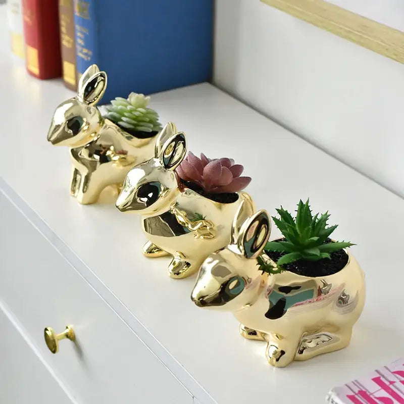 Modern golden ceramic flower pot shaped like a rabbit with a glossy finish holding succulents for living room décor