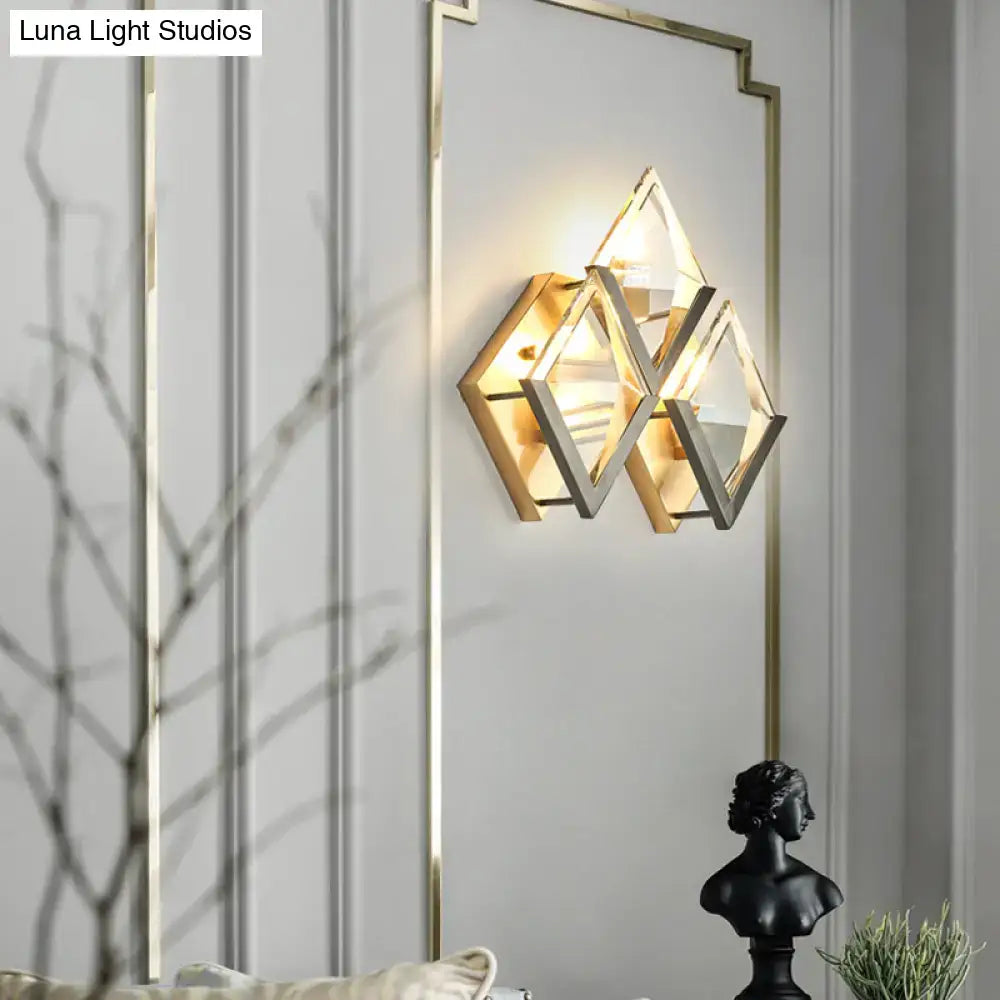 Modern golden wall sconce light with clear crystal triangular glass panels and brushed gold metal frame for bedroom use