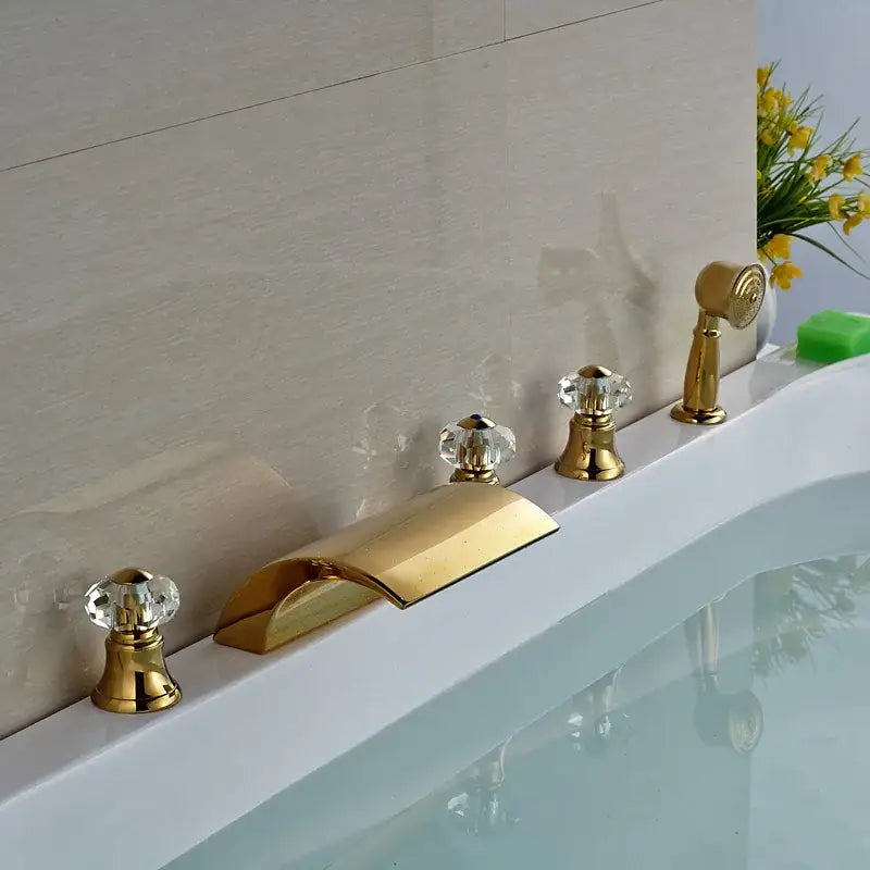 Modern golden widespread brass bathtub faucet with crystal knobs and handheld shower in sleek bathroom design