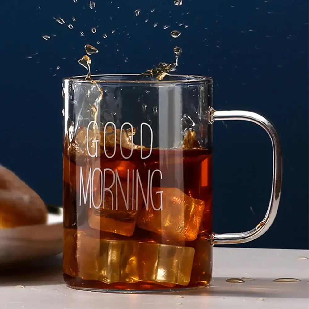 Clear glass mug with silver handle and good morning glass etching filled with iced coffee by decorbites good morning