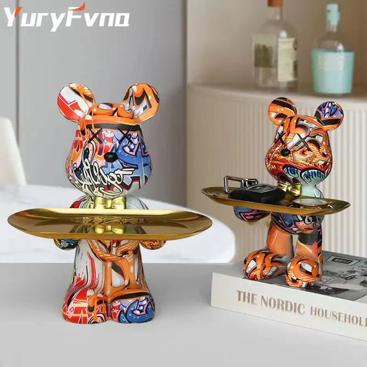 Modern graffiti bear figurine featuring vibrant orange blue and white paint holding golden trays for living room decor