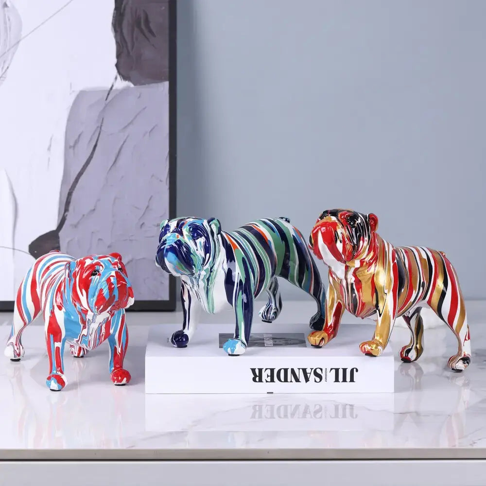 Three vibrant decorbites bulldog figurines with glossy ceramic finish and bold red blue green gold and black stripes
