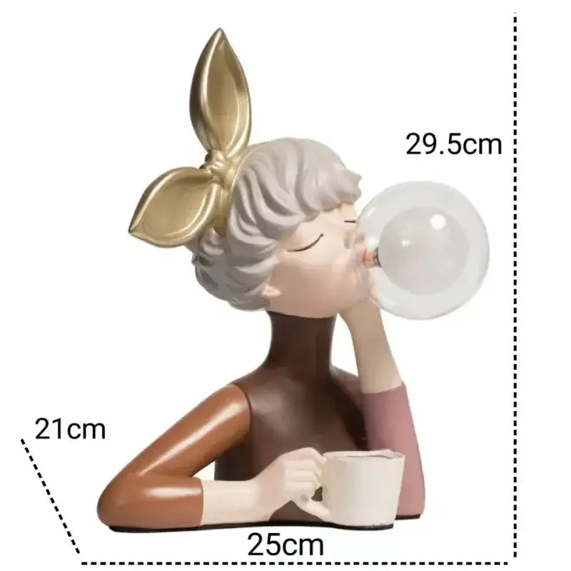 A charming resin figurine of a woman with short gray hair and a gold bow, blowing a clear bubble while holding a white mug.