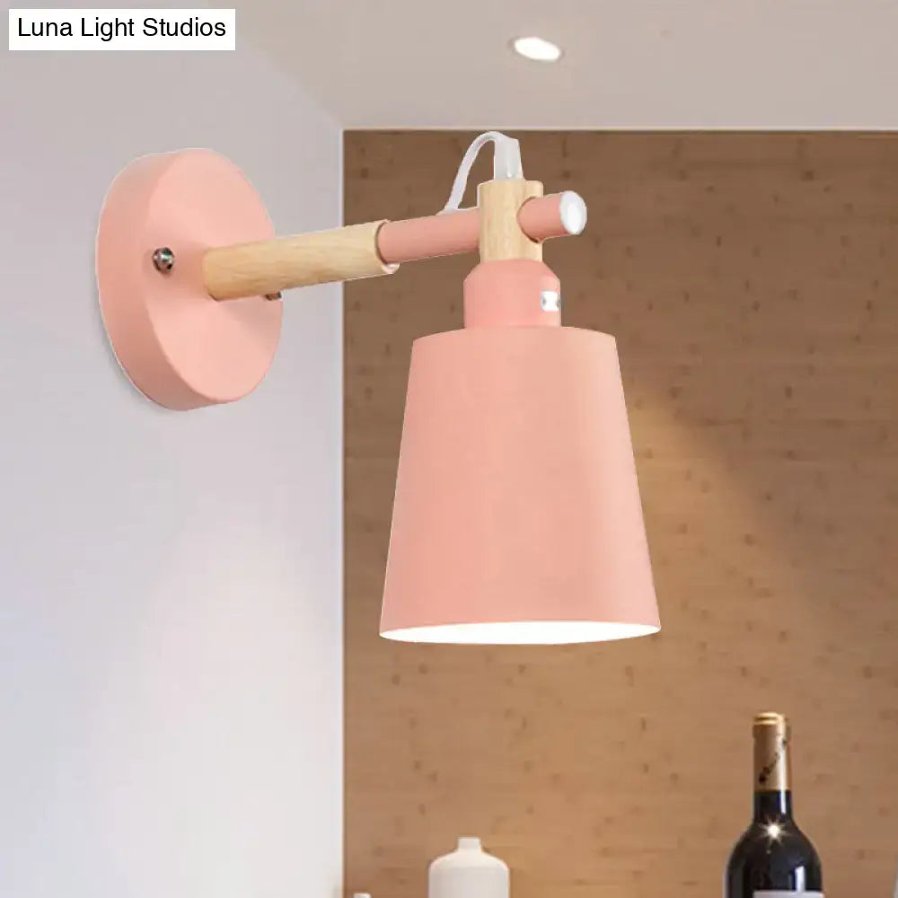 Modern gray and wood wall sconce light with pastel pink conical shade and wooden arm for bedroom use