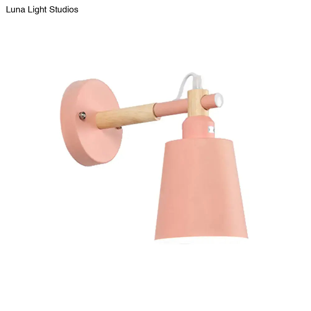 Pastel pink wall sconce light with wooden arm and matching conical shade for modern bedroom decor