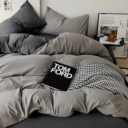 Modern gray comforter cover set with subtle sheen and matching pillowcases accented by black and white geometric throw
