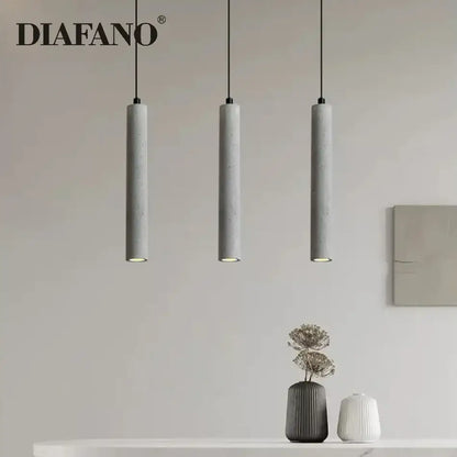 Modern gray concrete tube pendant light with three sleek cylindrical shades hanging from black cords for dining room decorbites concrete tube pendant