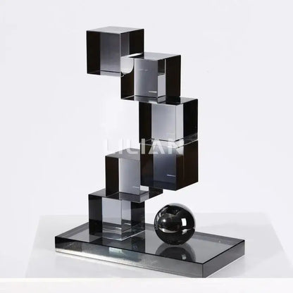A sleek modern gray geometric crystal glass sculpture with stacked black cubes and a polished sphere for living room decor