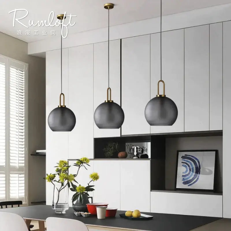 Three sleek matte black glass ball pendant lights with brass accents for dining room decorbites glass ball lighting