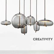 Set of modern gray glass chandelier knot pendant lamps with translucent shades and black cords for dining room lighting