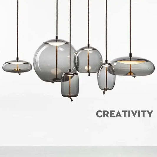 Set of modern gray glass chandelier knot pendant lamps with translucent shades and black cords for dining room lighting
