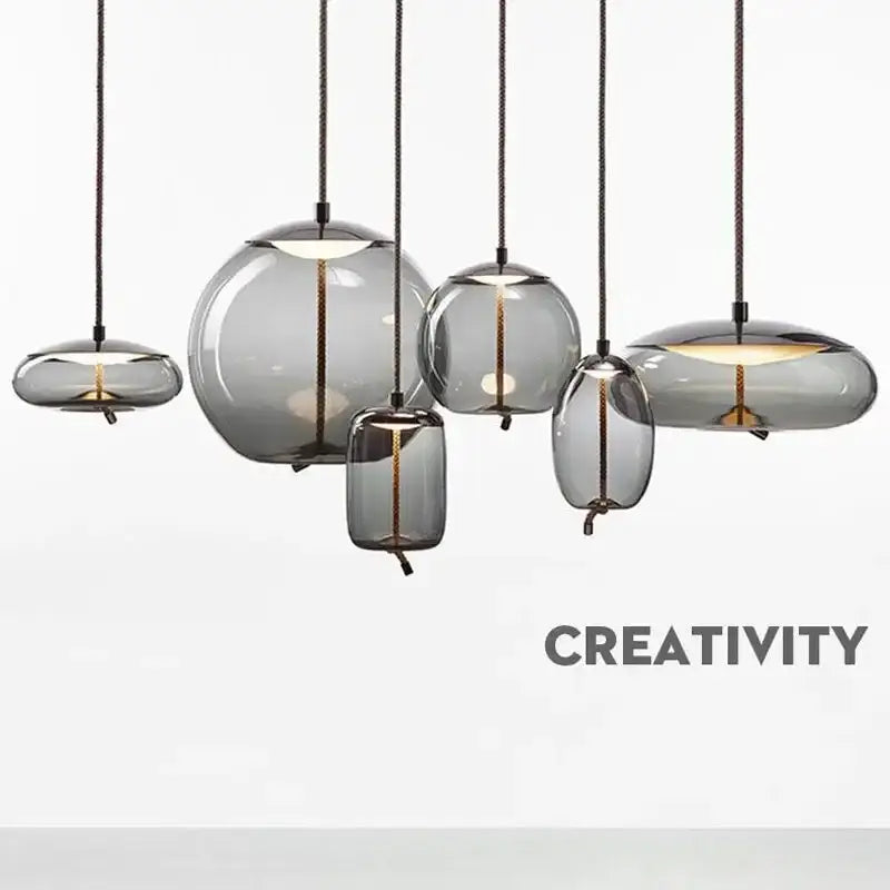 Set of modern gray glass chandelier knot pendant lamps with translucent shades and black cords for dining room lighting