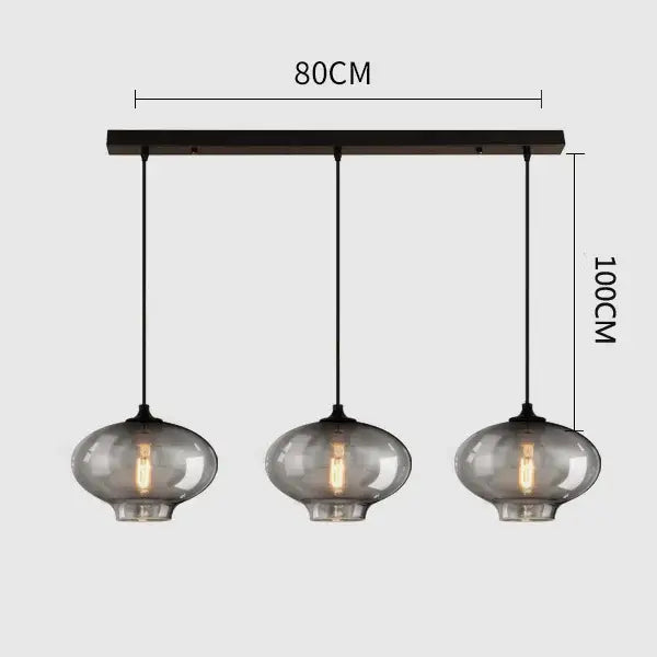 Modern black metal pendant light with three gray glass smoked globes featuring exposed filament bulbs for dining room