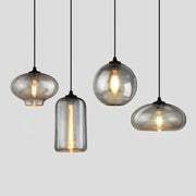 Set of four modern gray glass pendant lights with smoked glass shades and exposed filament bulbs for dining room lighting