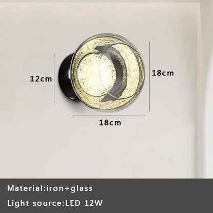 Circular gray glass wall lights with textured frosted finish and black iron base for modern living room sconce