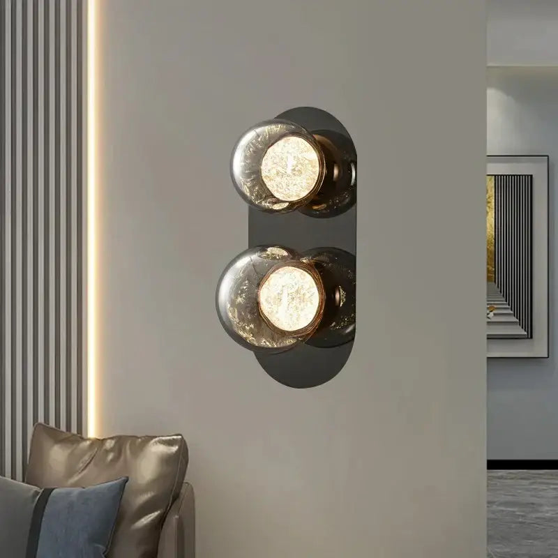 Modern black sconce wall lights with gray frosted glass globes and sleek metal backplate for living room use