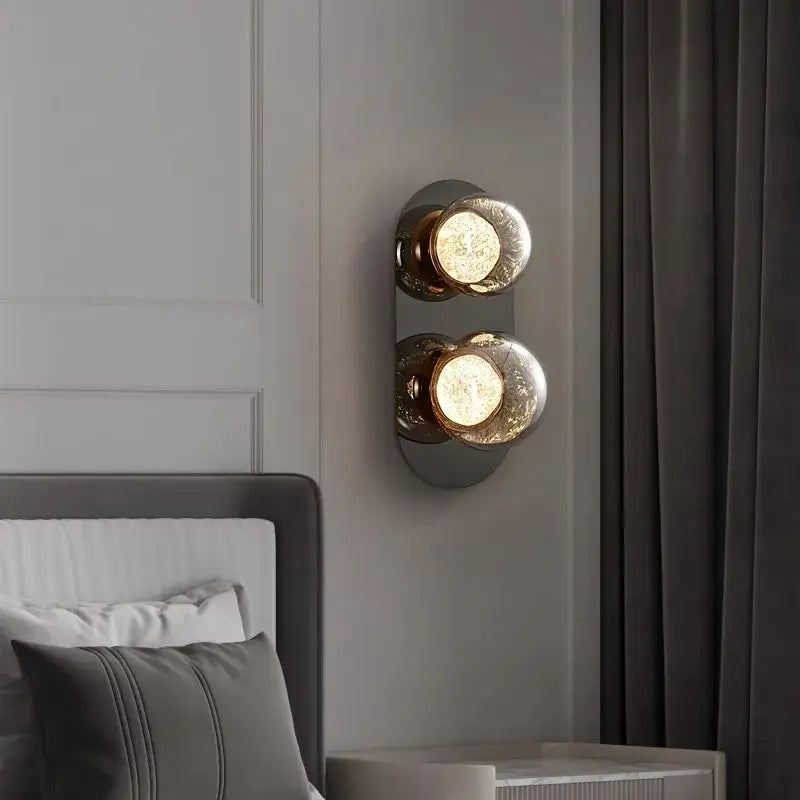 Modern double-head wall lights with gold-toned metal and gray textured frosted glass globes for living room use