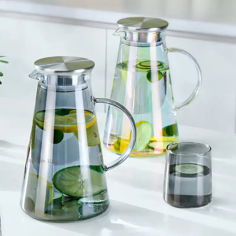Modern gray glass water pitcher with stainless lid filled with water and sliced lemons and limes for kitchen use