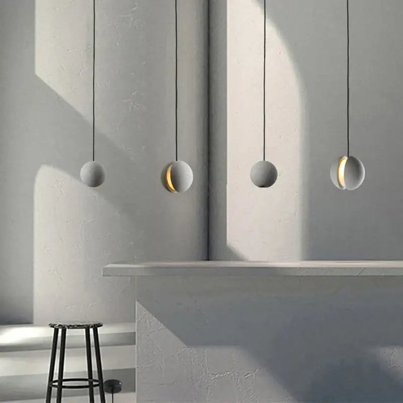 Modern gray and gold cement chandelier with four matte gray spherical pendant lights and subtle golden inner glow by decorbites cement chandelier