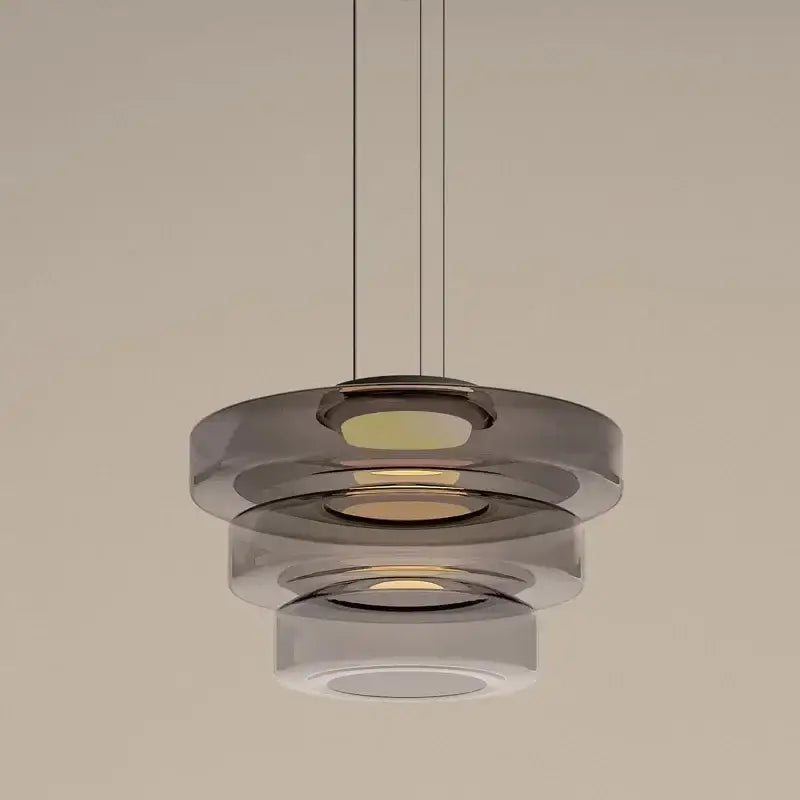 Modern gray and green tiered glass pendant light with translucent glass rings and warm glow for dining room