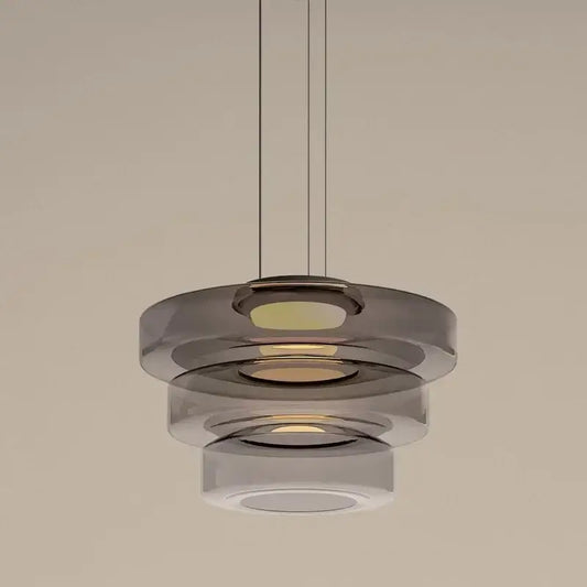 Modern gray and green tiered glass pendant light with translucent glass rings and warm glow for dining room