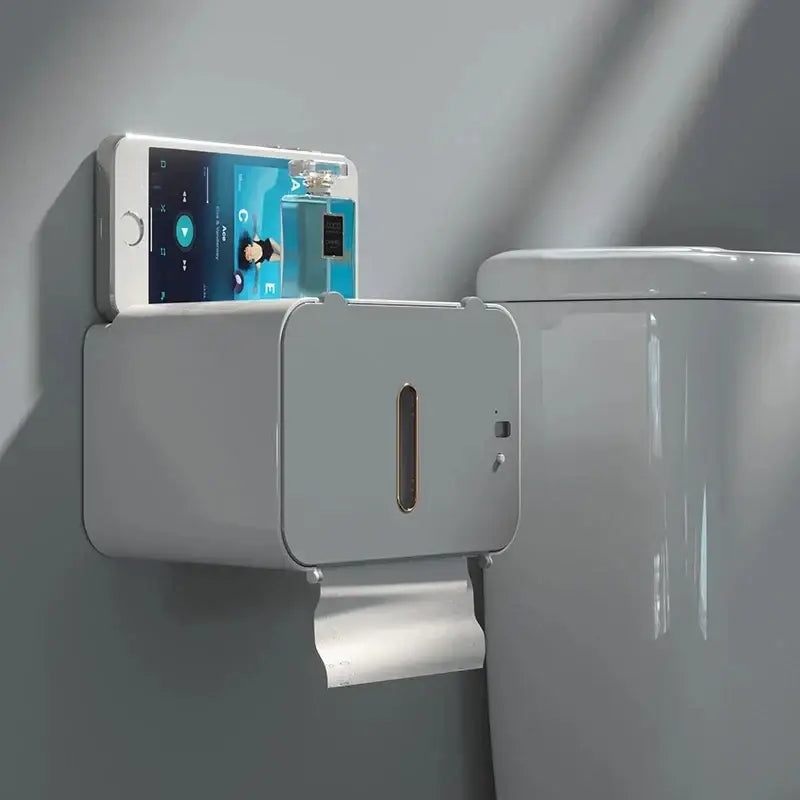 Modern gray induction toilet paper holder with phone slot mounted on wall holding white smartphone for bathroom use