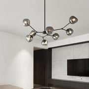 Modern black metal chandelier with frosted glass globe shades featuring gray lava glass for dining room lighting