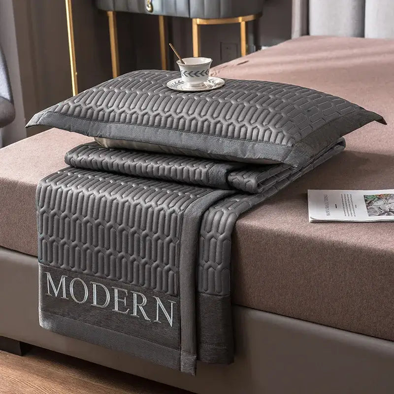 Gray quilted cooling latex bed mat with modern embroidered design and modern lettering for bedroom use
