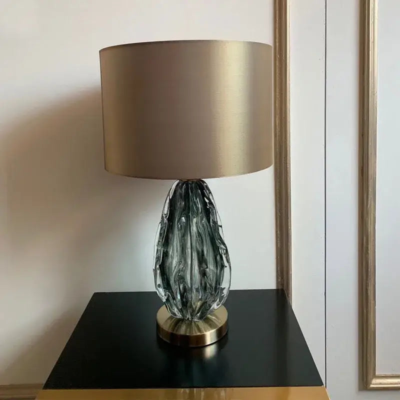 Modern gray swirl crystal table lamp with a sleek textured gold glass base and matching cylindrical shade for decorbites decor