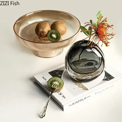 Dark gray spherical glass vase with a single orange artificial flower arrangement for modern home decor