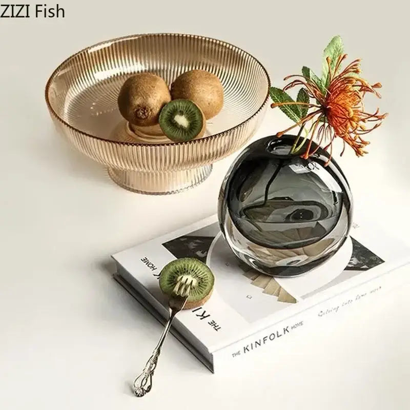 Dark gray spherical glass vase with a single orange artificial flower arrangement for modern home decor