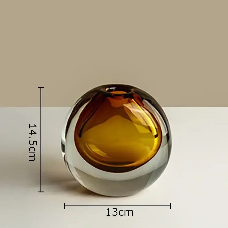 A sleek modern glass vase with gradient amber interior and artificial flowers for gray and teal home decor