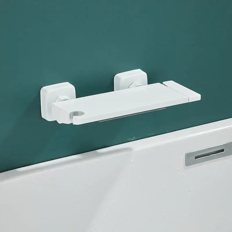 White plastic wall mounted bathtub shelf with two square brackets and central cutout paired with gray wall mounted waterfall faucet set