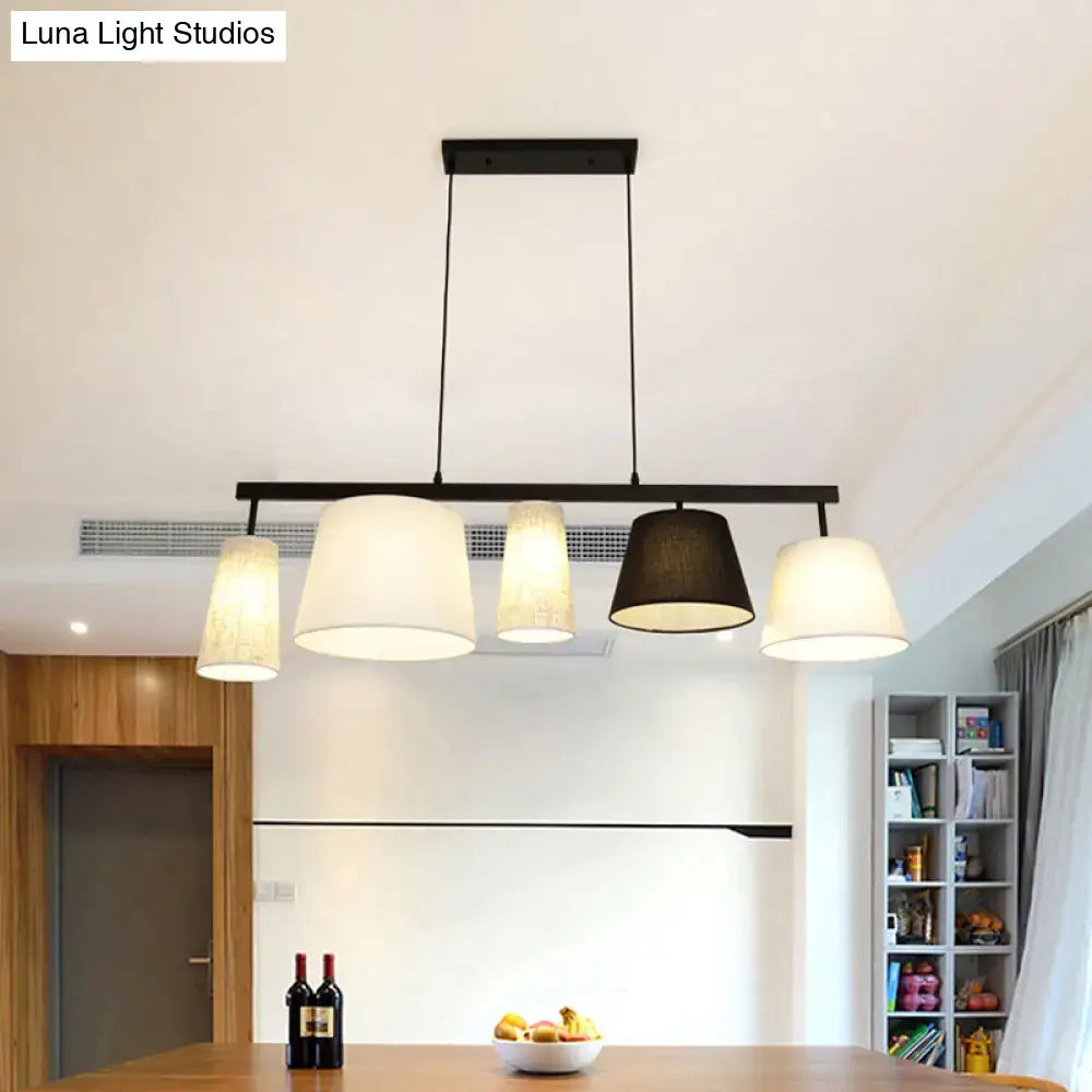 Modern black metal light fixture with four off-white and dark gray fabric shades in DecorBites barrel hanging light kit