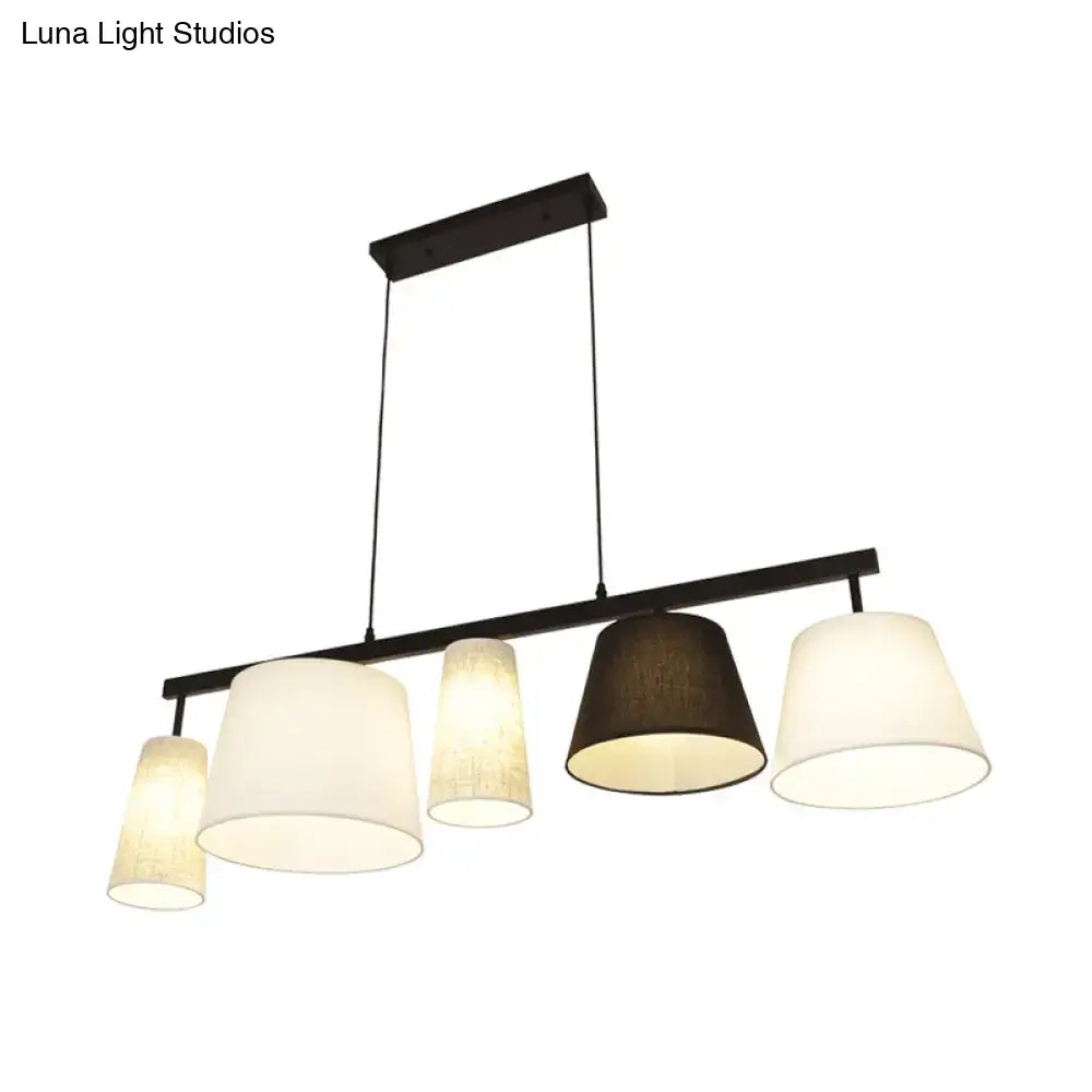 Modern black metal light fixture with five cylindrical off-white and dark brown fabric shades barrel hanging light kit