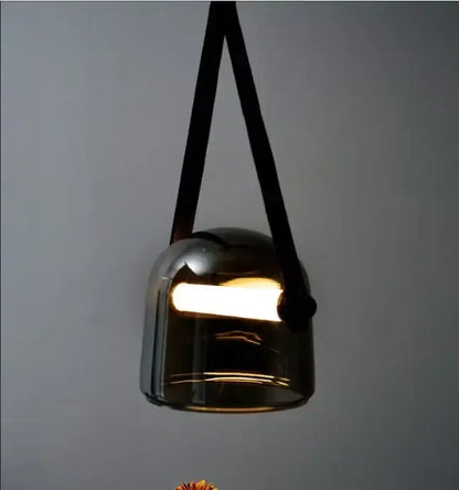 A modern decorbites glass chandelier with dark-tinted glass and black leather straps for gray and white living room decor