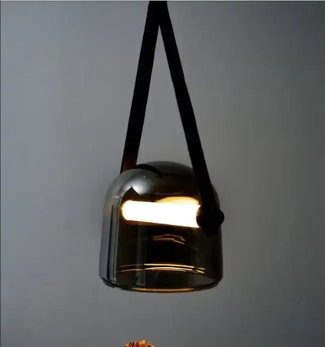 A modern decorbites glass chandelier with dark-tinted glass and black leather straps for gray and white living room decor