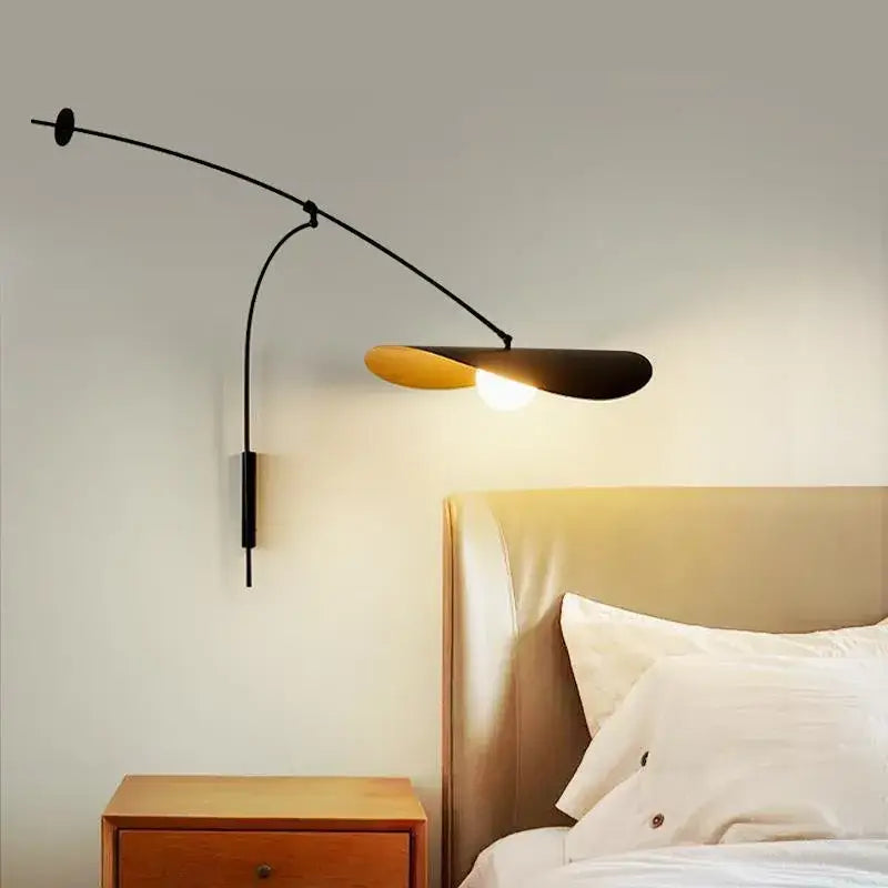 Black metal wall-mounted lamp with curved arm and leaf-shaped shade featuring warm golden interior for decorbites adjustable led pendant chandelier