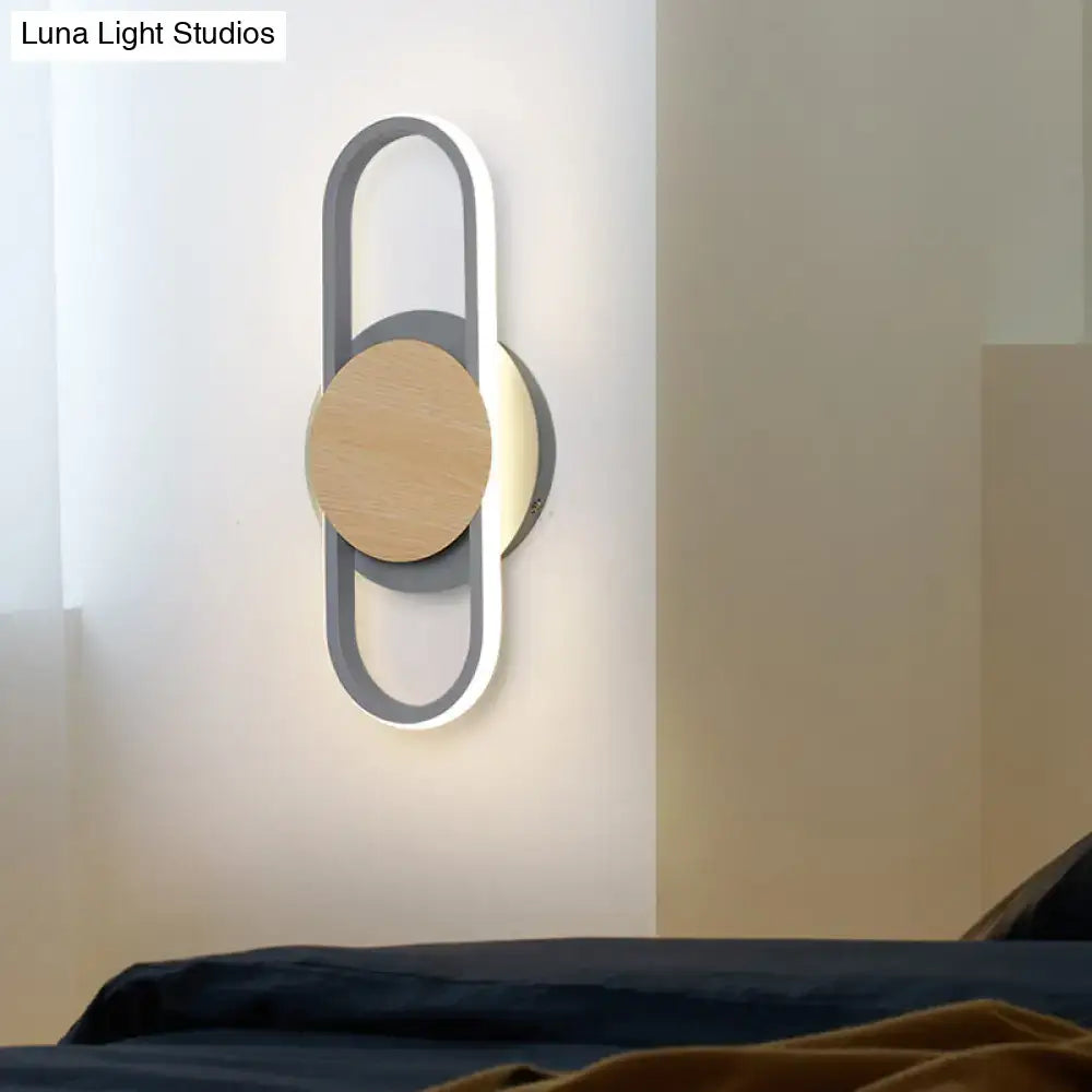 Modern gray and wood geometric led sconce with circular wooden accent and soft white light for bedroom lighting