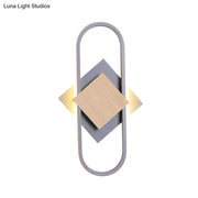 Modern gray and wood geometric LED wall sconce with sleek minimalist design providing white light for bedroom use