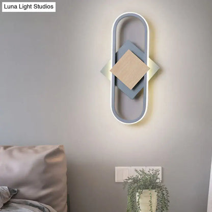 Modern gray and wood geometric led sconce with layered diamond panels emitting white light for bedroom lighting