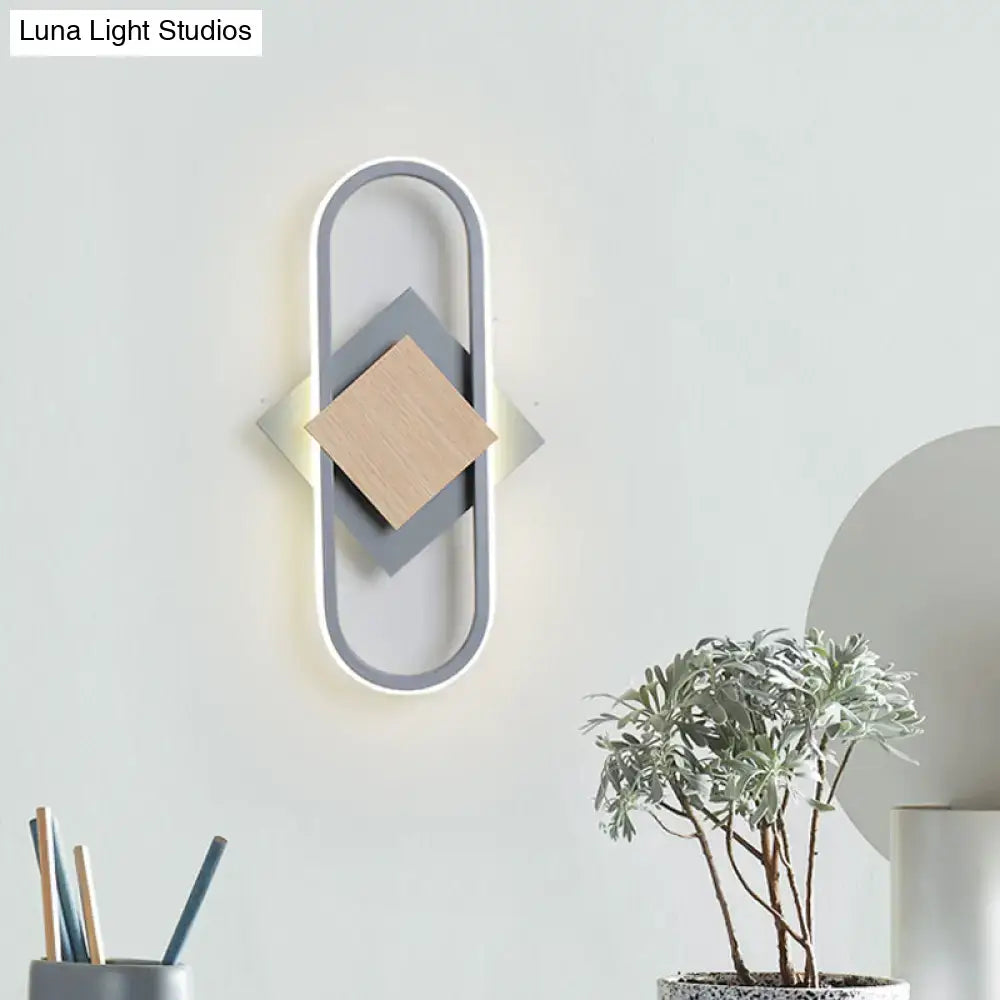Modern gray and wood geometric led sconce with layered diamond panels emitting white light for bedroom use