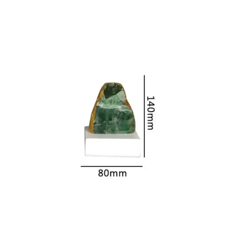 Polished green agate crystal stone bookend with golden mineral inclusions on white rectangular base for living room decor