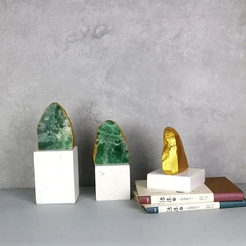 Three polished green agate crystal stone geode slices with gold accents on white marble bases for living room decor