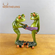 Modern green and orange leggy frog couple resin figurine holding a purple belt for living room decor by decorbites