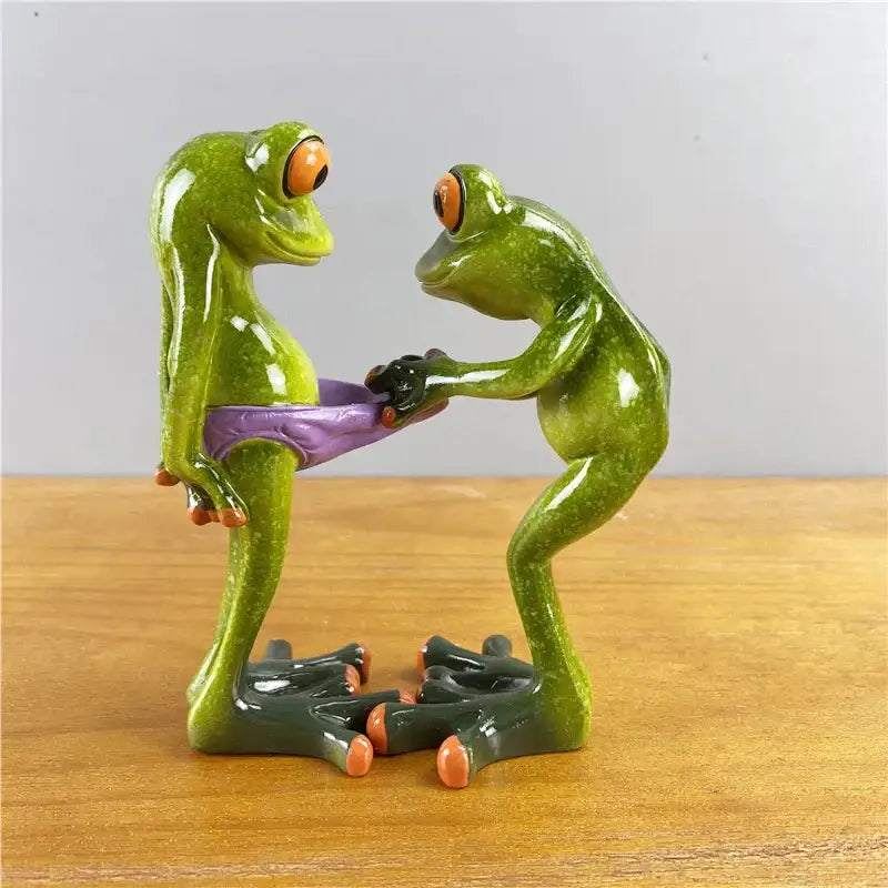Modern green and orange resin decorbites leggy frog couple figurine holding waist in playful living room decor pose